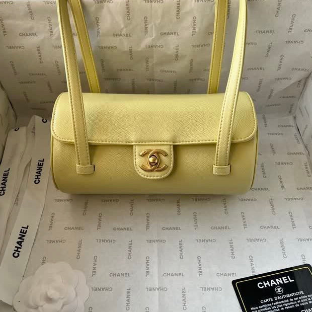 Yellow handbag with gold hardware on a Chanel branded background